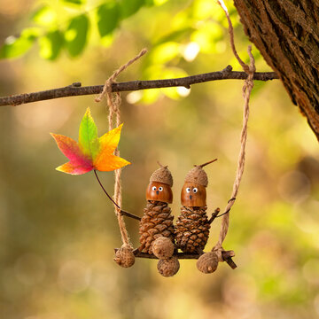 autumn forest acorn figures on a wooden swing in the colorful forest