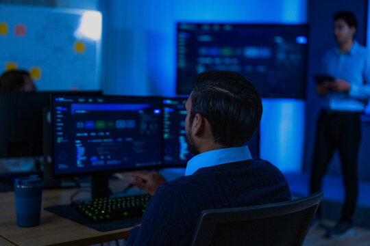 A detailed shot of an outstretched finger selecting a panel on screen captures the quiet routine of monitoring work after office hours at a leading data driven organisation