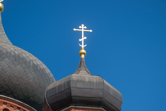 Golden cross gleaming atop the Holy Assumption Cathedral against a clear blue sky in Tula Russia
