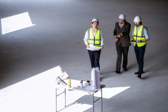 Senior manager visit walking meeting engineering experts, engineer managers reporting skyscraper construction progress investor site temporary table temporary workspace site.