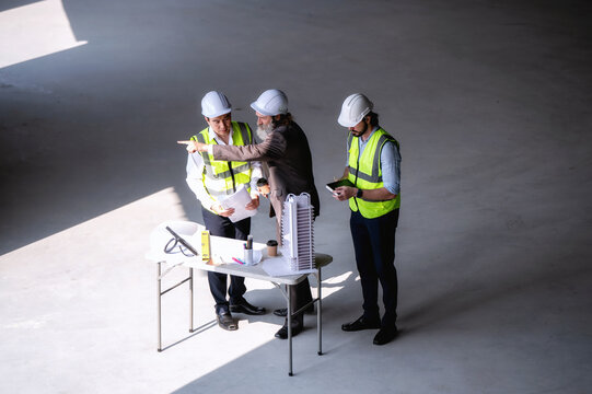 Senior manager provide advice to engineer managers team while presented building structure process with scale model at site. Concept of brainstorming in construction project management.