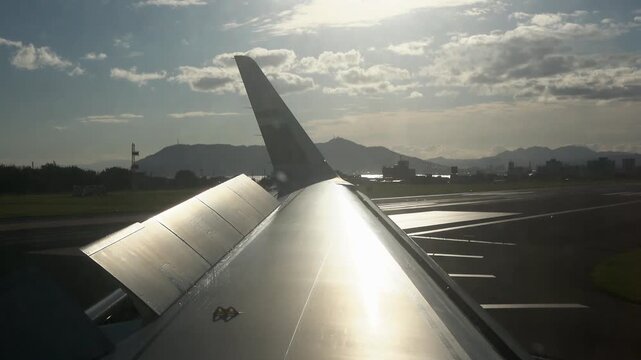 Looking out a cabin window at wing spoilers stowing after landing and slowing down.