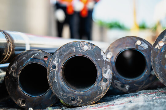 Close-up view of durable round metal tubes with bolt holes for water supply or oil transport. Concept of pipeline infrastructure, fabrication, and engineering.