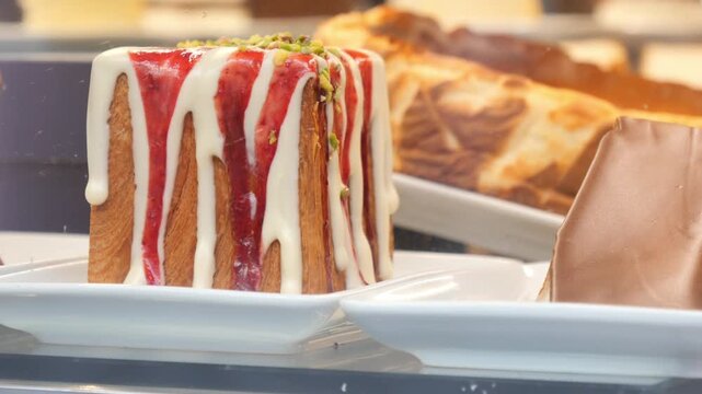 A close up view of delicious croissant square filled with cream and strawberry jam on top in a cafe window