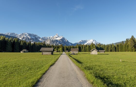 Hay barns in a meadow, Ehrwalder Sonnenspitz and mountains, near Ehrwald, Tyrol, Austria