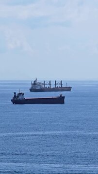 Two large cargo ships navigating the open sea, representing global trade, rising fuel prices, and the risk of international conflict and economic crisis due to geopolitical tensions