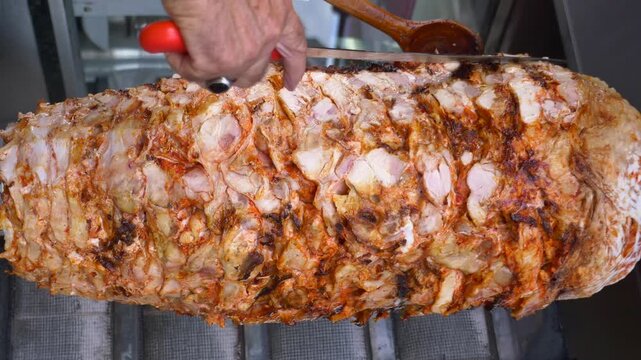 Chef skillfully slices a large, rotating spit of seasoned meat, preparing savory shawarma for hungry customers with dynamic motion