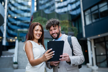 Business professionals collaborating using digital tablet outdoors © Zoran Jesic