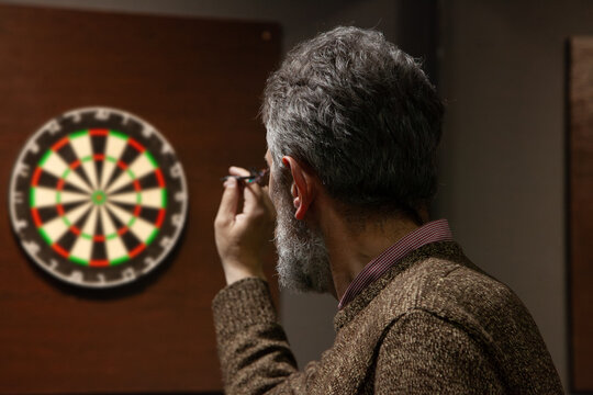 Bearded man playing darts