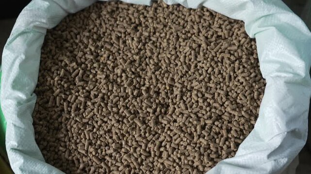 High Angle View of Brown Animal Feed Pellets Bulk in a White Woven Sack