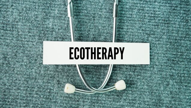 Stethoscope and paper with the word Ecotherapy. structured healing practice that involves interacting with nature to improve mental, emotional, and physical well-being.