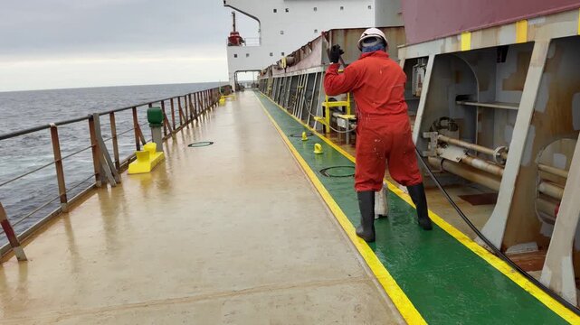 moping ship main deck during sea passage by deckhands.