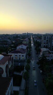 Aerial drone view of the central streets and urban architecture of Poti, Georgia, filmed vertically in 4K on September 15, 2024. The footage shows the city center, streets, buildings, and urban landsc