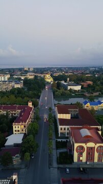 Aerial drone view of the central streets and urban architecture of Poti, Georgia, filmed vertically in 4K on September 15, 2024. The footage shows the city center, streets, buildings, and urban landsc