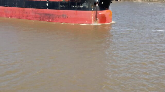 close view of forward part of cargo ship with bulb and anchors ready to drop.