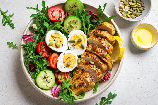 High protein lunch bowl with chicken, eggs and vegetable salad.