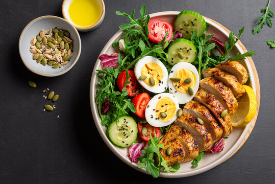 High protein lunch bowl with chicken, eggs and vegetable salad.