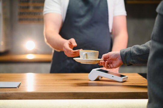 Barista serving coffee to customer at cafe