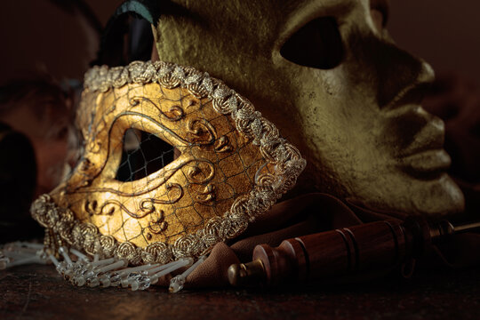 Golden carnival masks on a brown background.