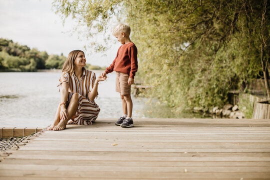 Joyful moments by the lakeside with a mother and her son enjoying nature
