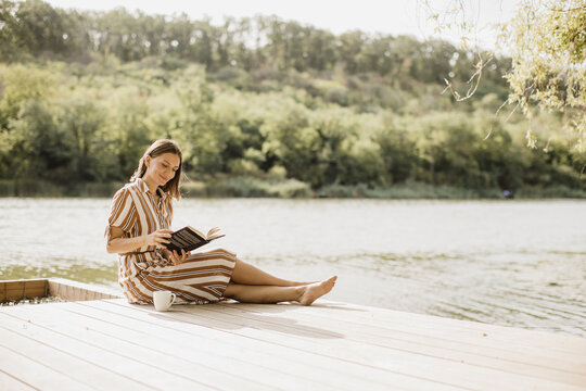 Quiet moments by the lake with a book and a warm drink in hand
