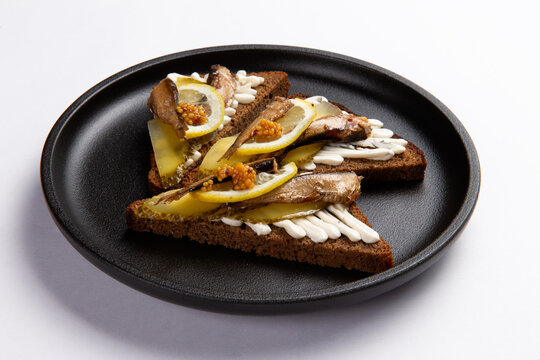 Smoked sardine rye bread slices with lemon pickles food preparation