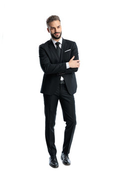 Elegant man in black suit standing with crossed arms