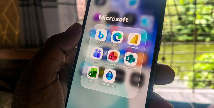 Smartphone display featuring organized microsoft mobile application icons in grid folder on touchscreen interface.
