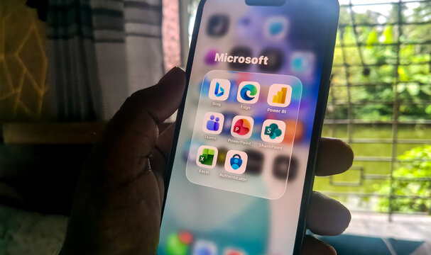 Smartphone display featuring organized microsoft mobile application icons in grid folder on touchscreen interface.