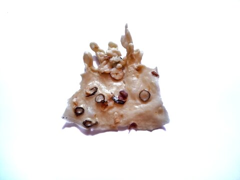 Crispy traditional Indonesian peanut crackers, known as rempeyek kacang, isolated on a clean white background.