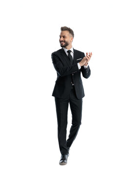 Enthusiastic man walking and clapping while looking to side