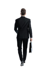 Back view of professional man walking holding briefcase