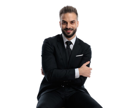 Handsome man sitting and folding arms while smiling