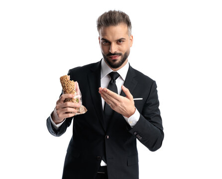 Confident formal man presenting half eaten sandwich