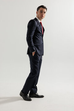 Side view of confident man standing with hands in pockets
