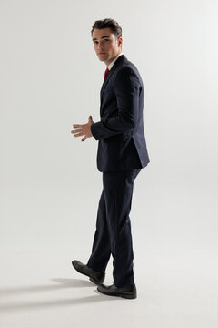 Side view of elegant man walking and rubbing hands