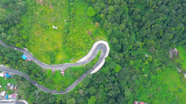 Aerial View of Dramatic Hairpin Road Through Lush Green Forest