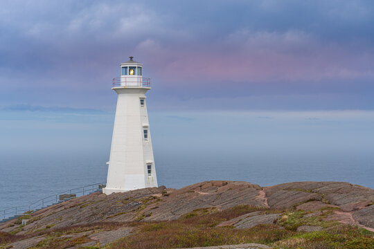 Wei&szlig;er Leuchtturm von Cape Spear auf einer felsigen Klippe am Meer in Neufundland