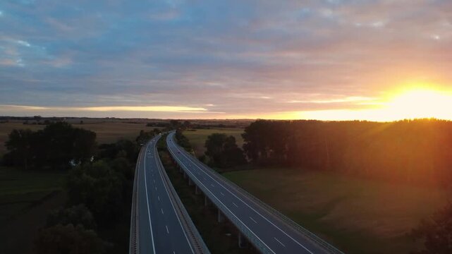Aerial drone shot flying forward over a German Autobahn highway at sunset near Triwalk