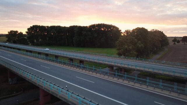 Drone ascending shot over autobahn highway bridge at sunset in Triwalk Germany
