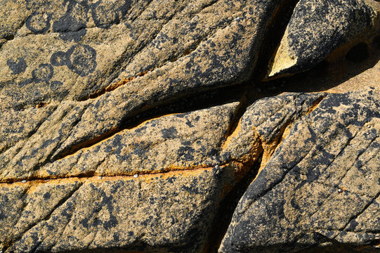 A granite rock furrow formation on the Atlantic coast, with grooves and crevices carved out by the waves and seawater, weathered and eroded.