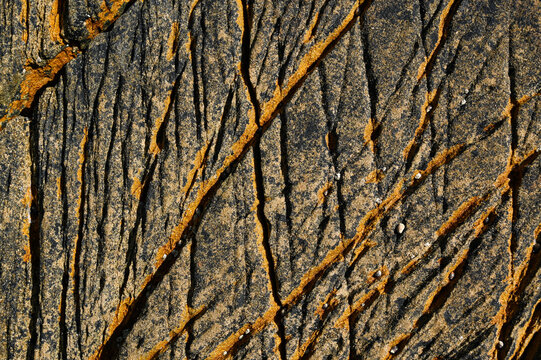 A granite rock furrow formation on the Atlantic coast, with grooves and crevices carved out by the waves and seawater, weathered and eroded.
