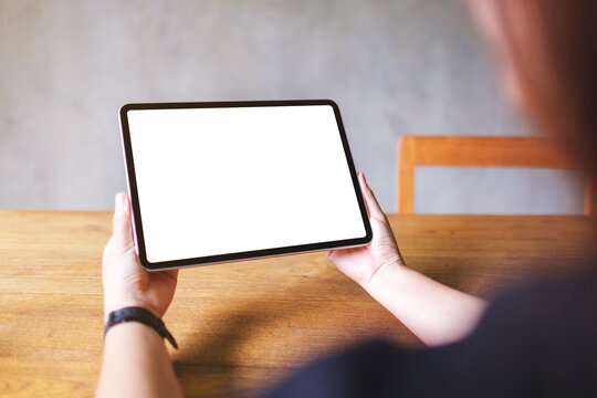 Mockup image of a woman holding digital tablet with blank white desktop screen