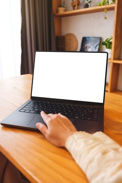 Vertical mockup image of a woman working on laptop computer with blank screen at home