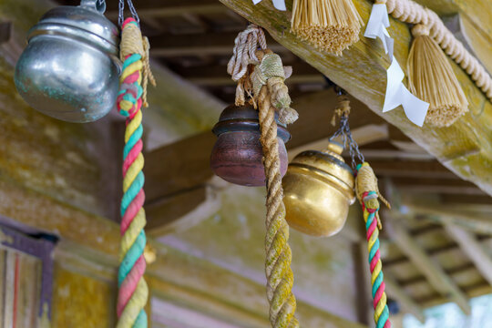 神社の注連縄の下に並ぶ鈴