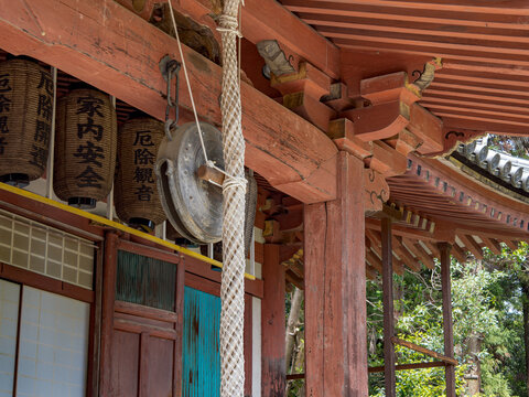 木造寺院の軒下に下がる鰐口と提灯