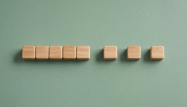 Wooden blocks arranged in sequence on green background representing progress or step by step achievement concept
