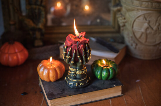 Burning heart candle held by witch hands on magical altar for love spells, cleansing negative energy and romantic rituals 