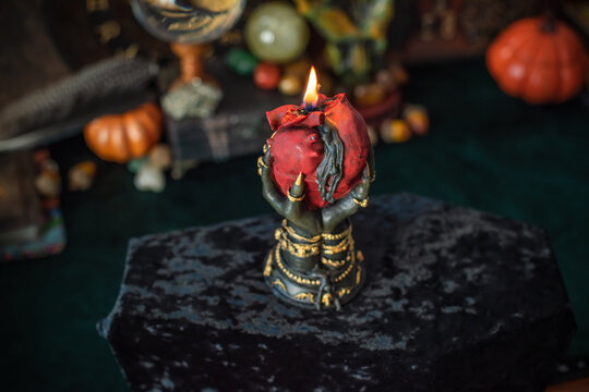 Burning heart candle held by witch hands on magical altar for love spells, cleansing negative energy and romantic rituals 