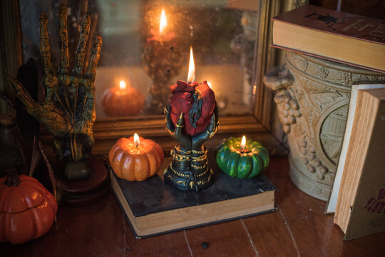 Burning heart candle held by witch hands on magical altar for love spells, cleansing negative energy and romantic rituals 